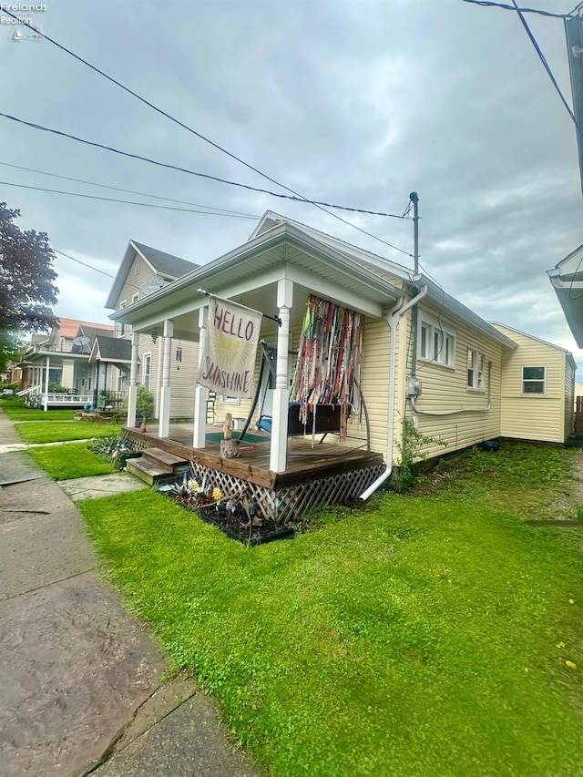 view of property exterior featuring covered porch and a yard