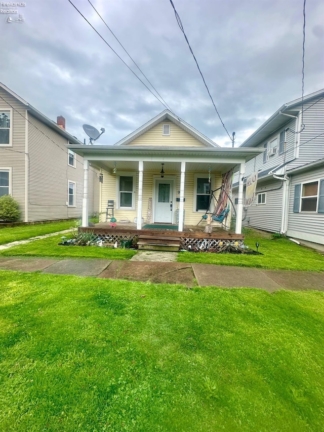 bungalow-style house featuring covered porch and a front yard