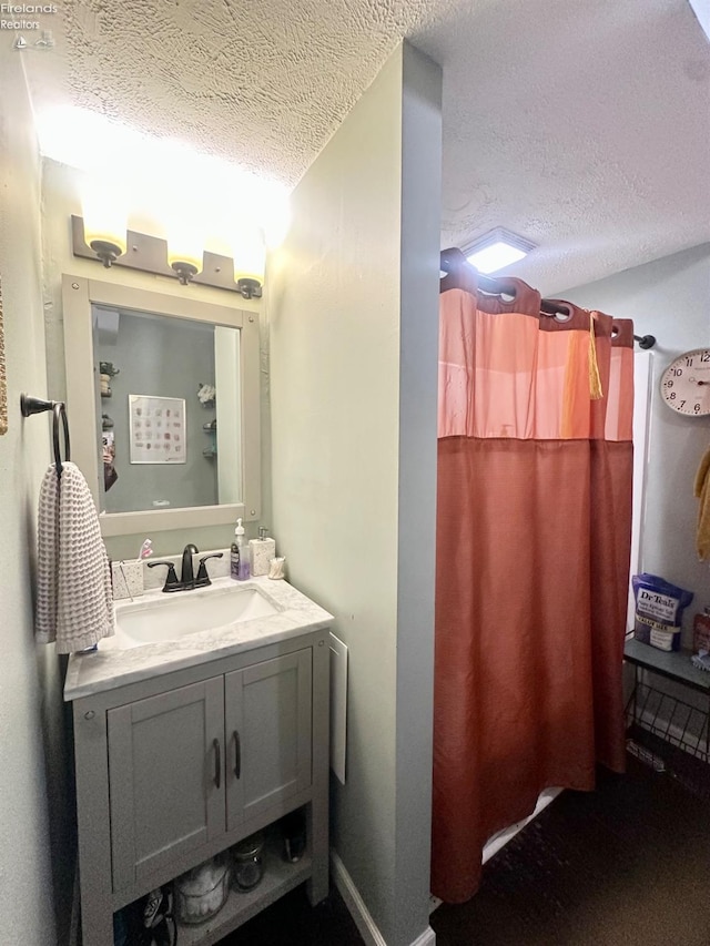 bathroom with vanity, a textured ceiling, and a shower with curtain