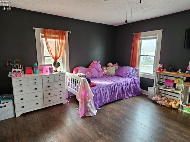 bedroom with a textured ceiling and wood finished floors