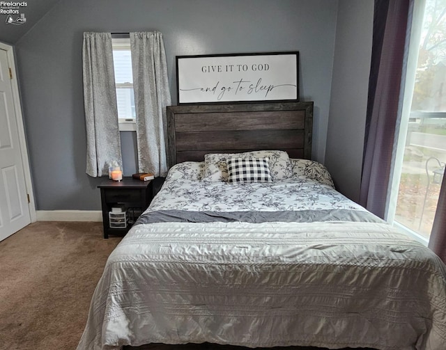 carpeted bedroom with baseboards and vaulted ceiling