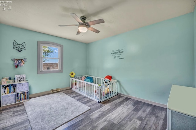 1733 County Road 302, Bellevue, OH 44811 - bedroom featuring wood finished floors, a crib, a ceiling fan, and baseboards