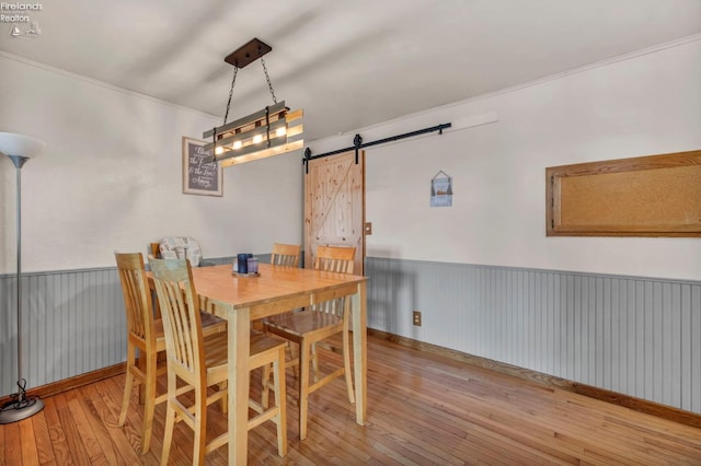 1733 County Road 302, Bellevue, OH 44811 - dining area with hardwood / wood-style flooring, a barn door, and wainscoting