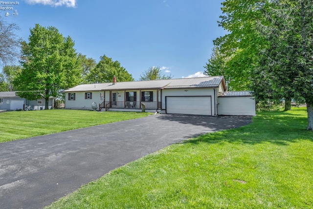 1733 County Road 302, Bellevue, OH 44811 - ranch-style house featuring an attached garage, a front yard, driveway, covered porch, and a chimney
