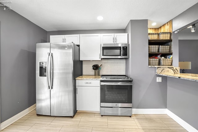 kitchen featuring baseboards, white cabinetry, tasteful backsplash, and stainless steel appliances