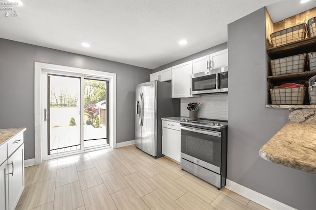 kitchen featuring baseboards, recessed lighting, white cabinets, backsplash, and stainless steel appliances