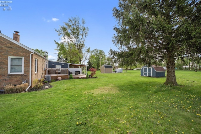 view of yard featuring a storage unit, an outdoor structure, and central AC