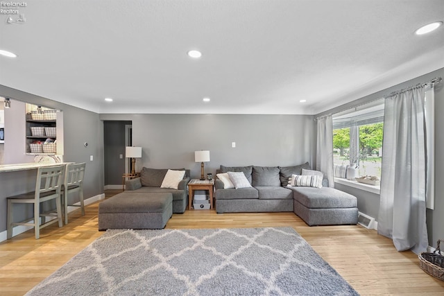 living room featuring recessed lighting, wood finished floors, and visible vents