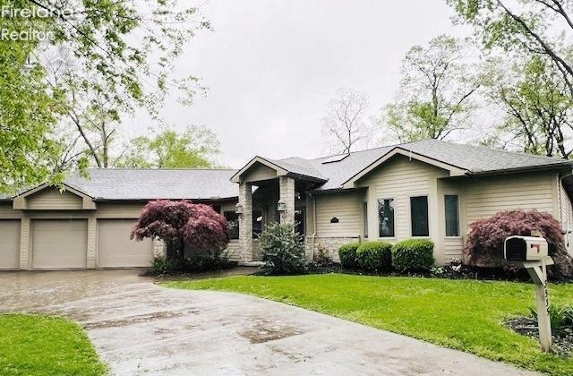 ranch-style house featuring an attached garage, a front yard, and concrete driveway