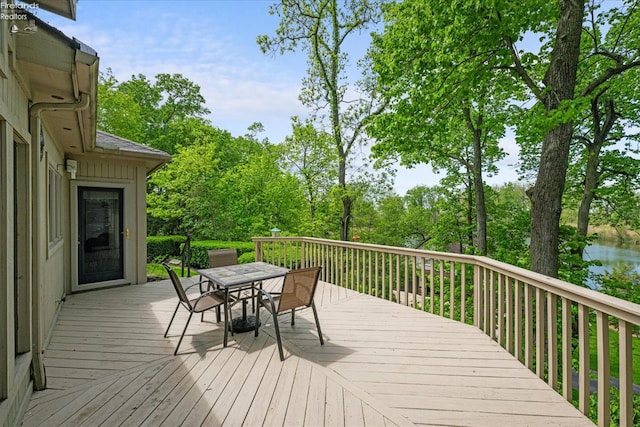 3535 E High Point Ln, Port Clinton, OH 43452 - wooden deck with outdoor dining area, view of scattered trees, and a water view
