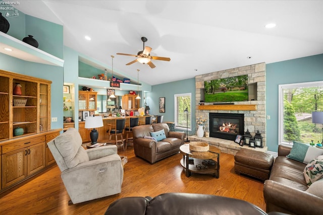 3535 E High Point Ln, Port Clinton, OH 43452 - living room with vaulted ceiling, healthy amount of natural light, light wood-type flooring, a ceiling fan, and a fireplace