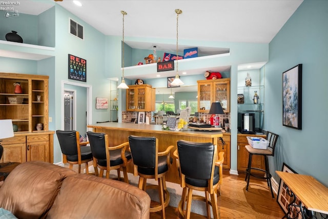 3535 E High Point Ln, Port Clinton, OH 43452 - indoor dry bar with light wood-style flooring, hanging light fixtures, and high vaulted ceiling