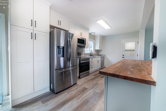 5033 Crestline Rd, Bucyrus, OH 44820 - kitchen featuring wooden counters, light wood-style flooring, a sink, white cabinetry, and appliances with stainless steel finishes