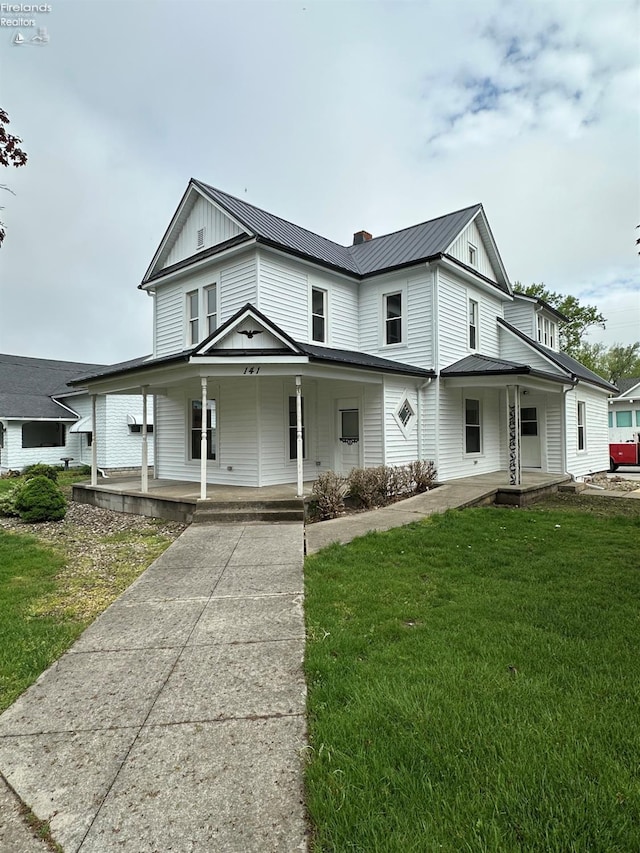 141 Main St, Castalia, OH 44824 - farmhouse featuring a front yard, a porch, a standing seam roof, and metal roof