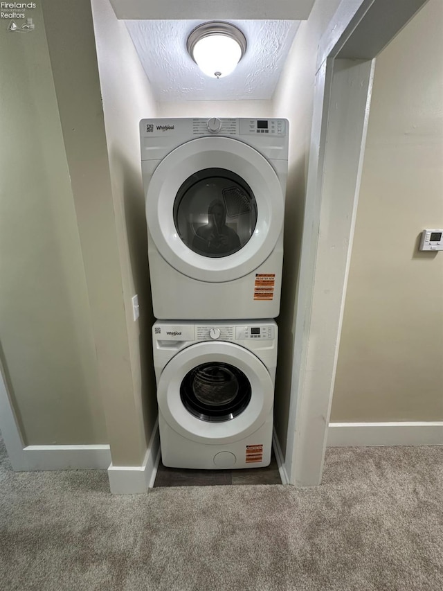 141 Main St, Castalia, OH 44824 - clothes washing area with stacked washer and clothes dryer, laundry area, baseboards, and carpet floors