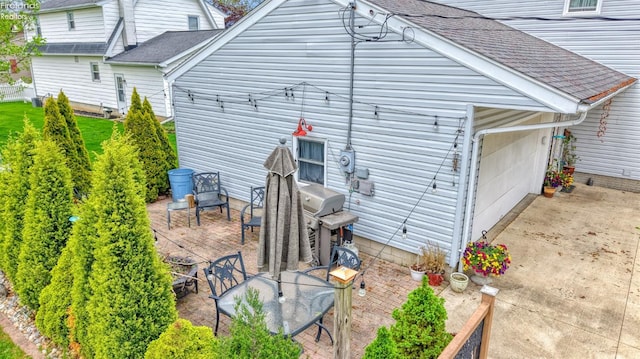 20 Chippewa Dr, Milan, OH 44846 - view of side of home with a shingled roof, a patio area, and a garage