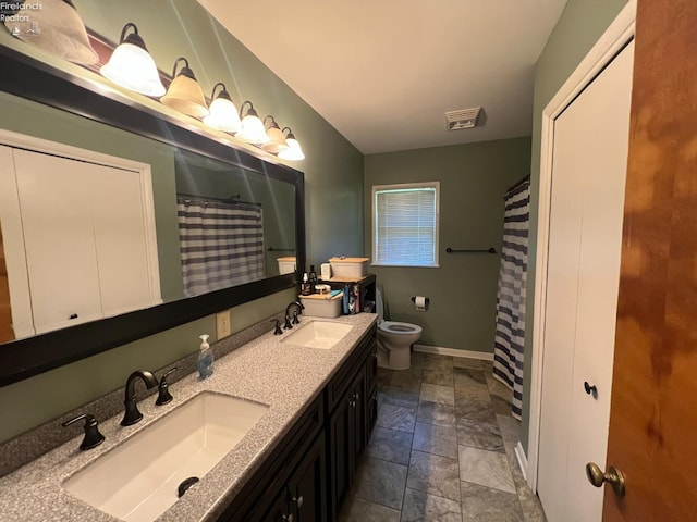 6 Breezewood Dr, Norwalk, OH 44857 - full bathroom with stone tile flooring, baseboards, toilet, double vanity, and a shower with shower curtain