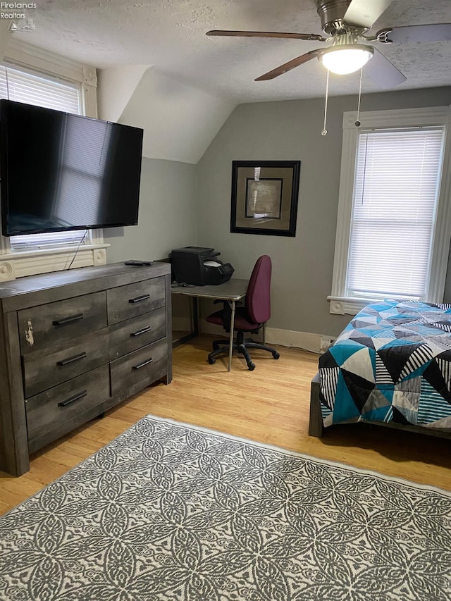 604 E Jefferson St, Sandusky, OH 44870 - bedroom with light wood-style flooring, multiple windows, lofted ceiling, baseboards, and a textured ceiling