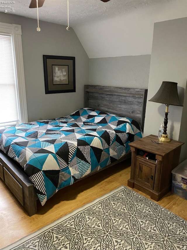 604 E Jefferson St, Sandusky, OH 44870 - bedroom featuring light wood-type flooring, vaulted ceiling, a ceiling fan, and a textured ceiling