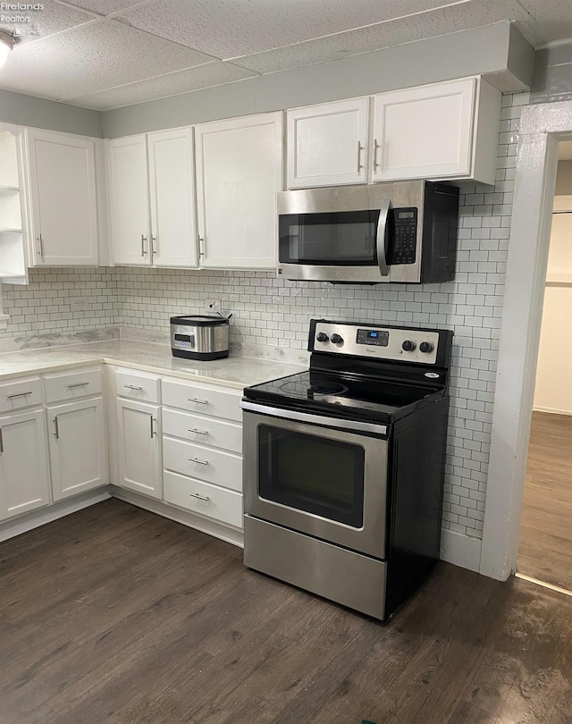 604 E Jefferson St, Sandusky, OH 44870 - kitchen featuring stainless steel appliances, white cabinets, dark wood-type flooring, decorative backsplash, and light countertops