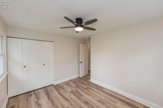 412 E 10th St, Port Clinton, OH 43452 - unfurnished bedroom with baseboards, light wood-type flooring, a closet, and a ceiling fan