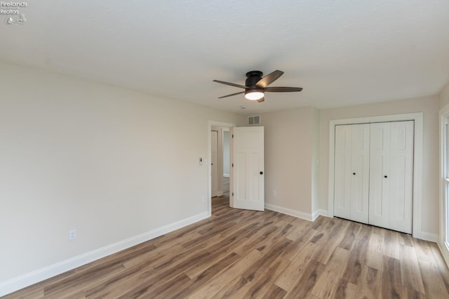 412 E 10th St, Port Clinton, OH 43452 - unfurnished bedroom with baseboards, wood finished floors, a closet, and ceiling fan