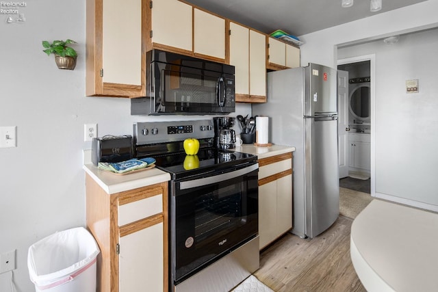 264 Clinton Reef Dr, Port Clinton, OH 43452 - kitchen featuring stainless steel appliances, stacked washer / drying machine, light countertops, and light wood-style flooring