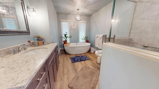 66 Hillcrest Dr, Willard, OH 44890 - full bathroom with wood finished floors, vanity, a freestanding bath, tiled shower, and baseboards