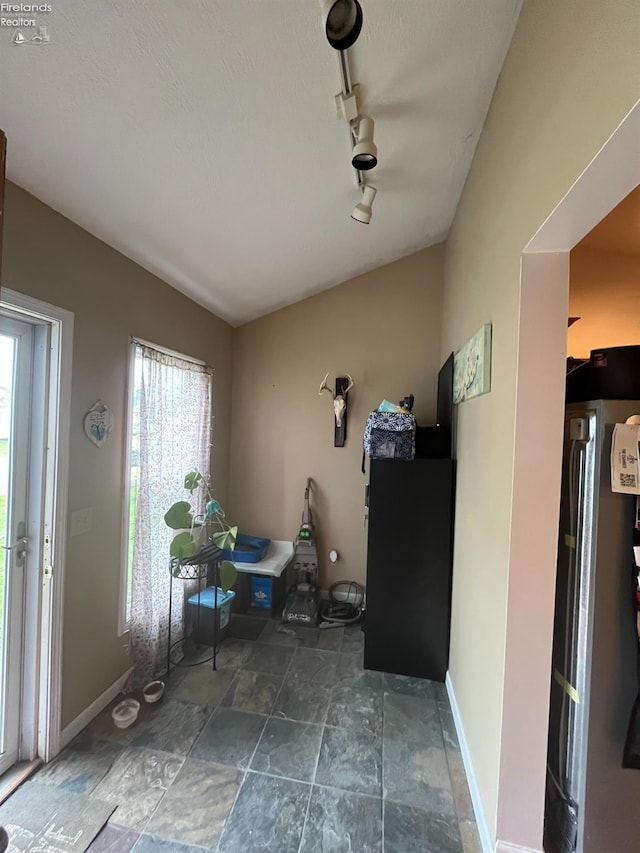 81 Melissa St, Tiffin, OH 44883 - interior space with healthy amount of natural light, lofted ceiling, baseboards, stone finish floors, and rail lighting