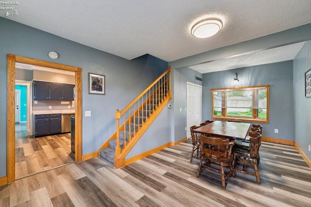 515 Berlin Rd, Huron, OH 44839 - dining room featuring light wood-type flooring, stairs, a textured ceiling, and baseboards