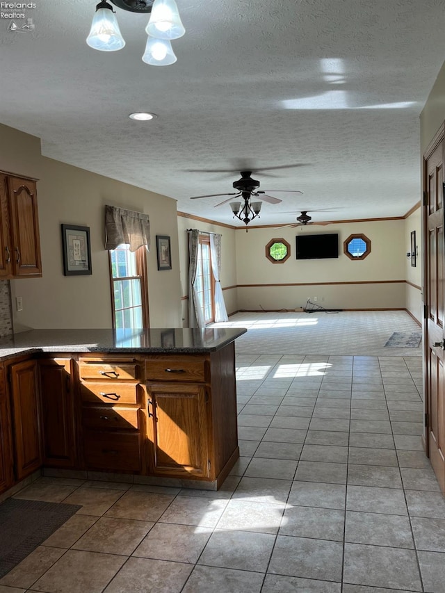 378 Lelar St, Tiffin, OH 44883 - kitchen with a textured ceiling, ceiling fan, light tile patterned flooring, dark countertops, and a peninsula
