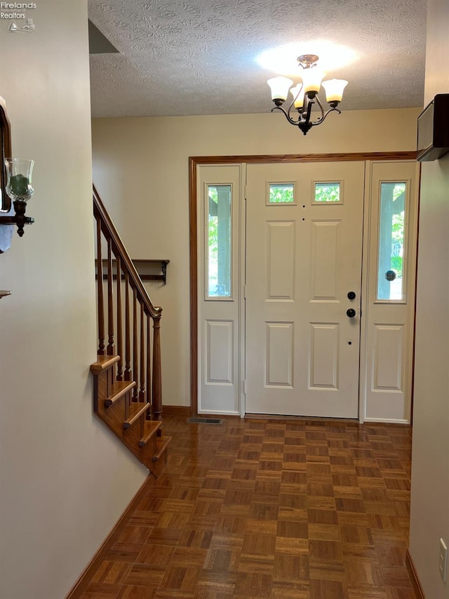 378 Lelar St, Tiffin, OH 44883 - entrance foyer featuring a chandelier, a textured ceiling, baseboards, and stairs