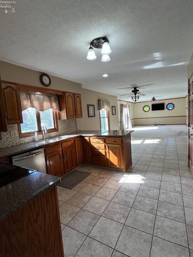 378 Lelar St, Tiffin, OH 44883 - kitchen with a peninsula, a textured ceiling, backsplash, light tile patterned flooring, and dishwasher