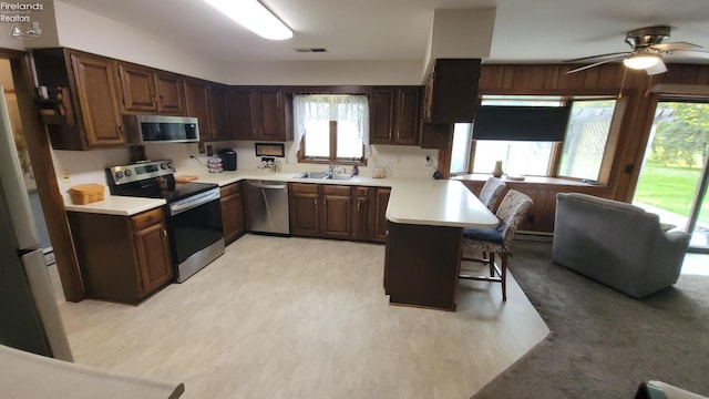 903 N Warpole, Upper Sandusky, OH 43351 - kitchen with stainless steel appliances, a sink, a peninsula, light countertops, and ceiling fan
