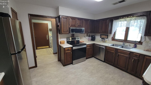 903 N Warpole, Upper Sandusky, OH 43351 - kitchen with stainless steel appliances, a sink, light countertops, light floors, and dark brown cabinetry