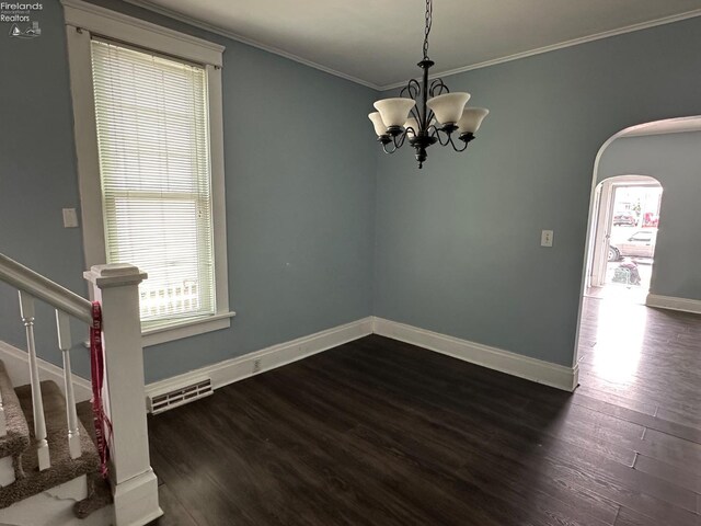 515 W Osborne St, Sandusky, OH 44870 - empty room featuring healthy amount of natural light, crown molding, dark wood finished floors, arched walkways, and baseboards