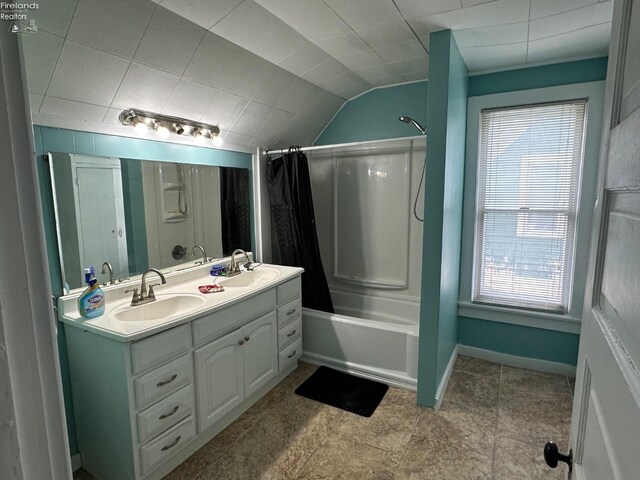 515 W Osborne St, Sandusky, OH 44870 - bathroom featuring shower / tub combo, double vanity, vaulted ceiling, and baseboards