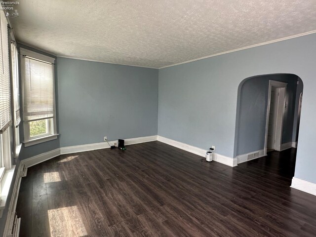 515 W Osborne St, Sandusky, OH 44870 - unfurnished room featuring a textured ceiling, arched walkways, dark wood finished floors, baseboards, and crown molding