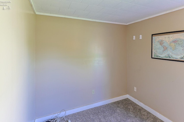 carpeted empty room featuring crown molding and baseboards
