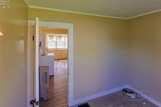 corridor featuring ornamental molding, wood finished floors, and baseboards