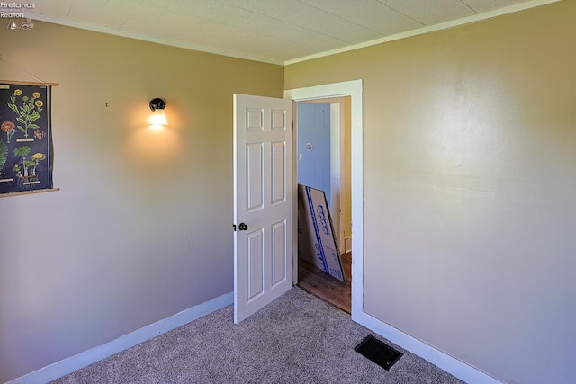 unfurnished bedroom featuring crown molding, carpet floors, and baseboards