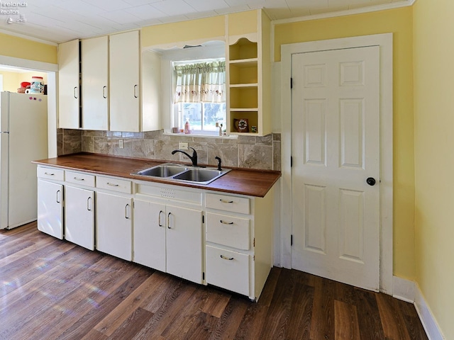 kitchen featuring a sink, butcher block counters, crown molding, and dark wood-style flooring