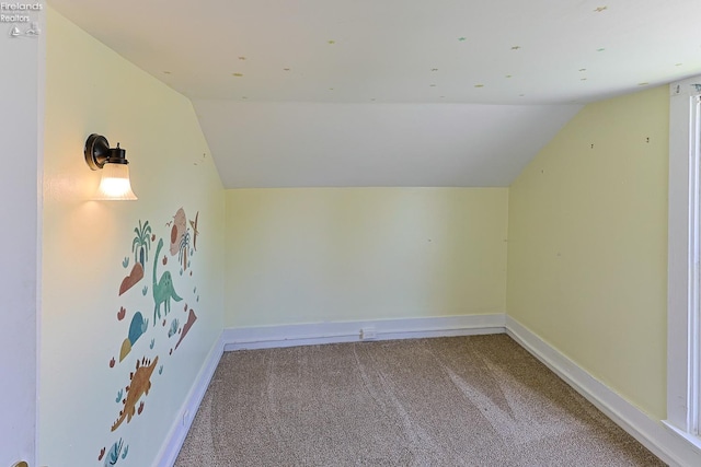 additional living space with vaulted ceiling, carpet, and baseboards