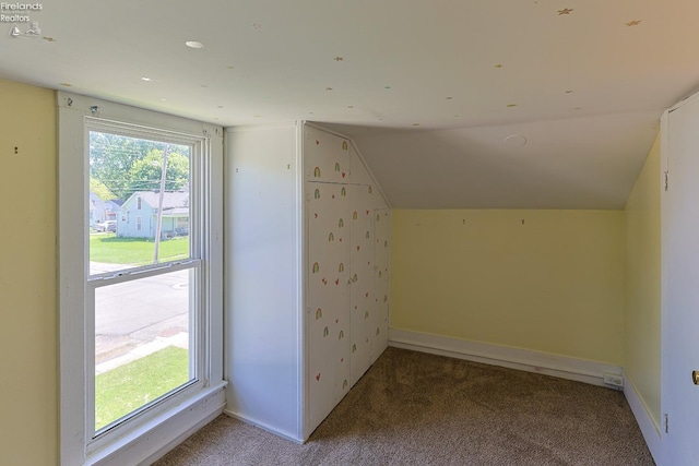 additional living space with carpet flooring, lofted ceiling, and baseboards