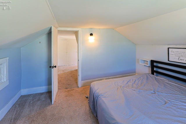 bedroom with carpet, vaulted ceiling, and baseboards