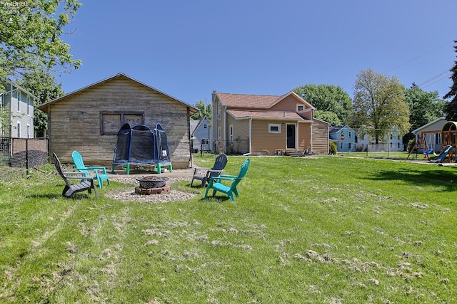 back of property with a fire pit, a playground, and entry steps