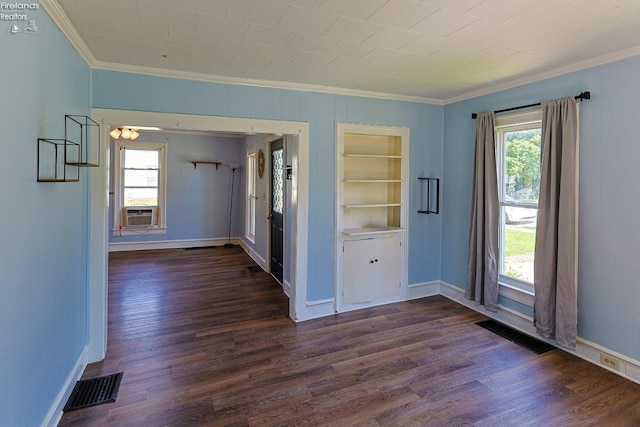 spare room with ornamental molding, healthy amount of natural light, dark wood-style flooring, and baseboards