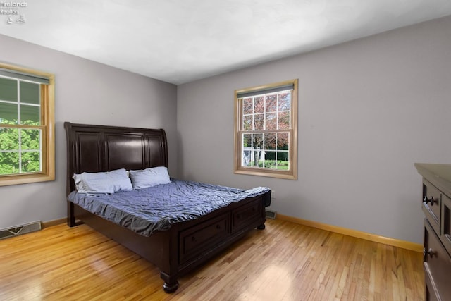 bedroom with baseboards and light wood-type flooring