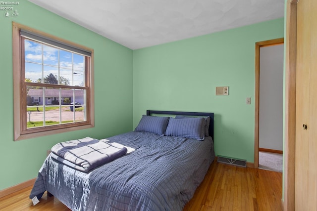 bedroom with wood finished floors and baseboards