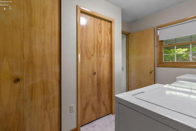 clothes washing area featuring washing machine and dryer and light marble finish floors